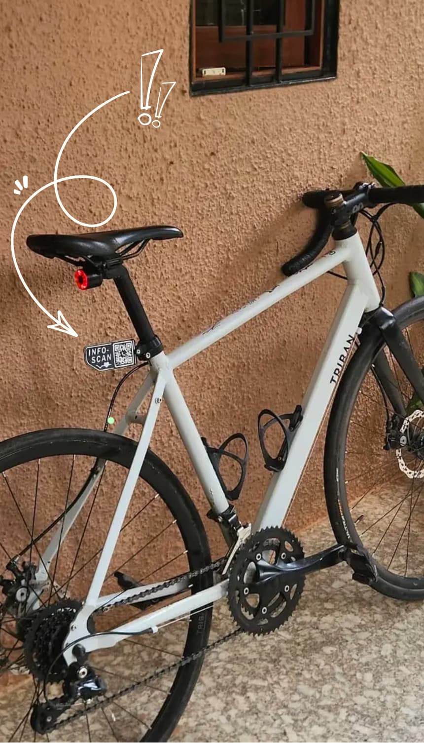 White road bicycle with a Pedalink QR tag mounted near the seat tube, highlighted by a drawn arrow.